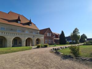 una casa grande con una entrada de grava delante de ella en Der Westflügel Knappe Tammo, en Stolpe auf Usedom