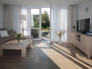 a living room with a couch and a tv at Der Landhof Sanddorn in Stolpe