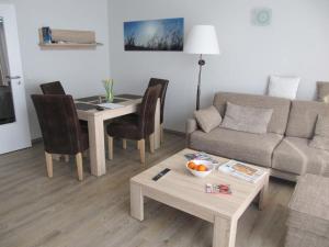 a living room with a couch and a table at Der Landhof Sanddorn in Stolpe