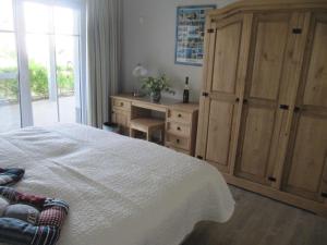 a bedroom with a bed and a dresser and a desk at Der Landhof Seeadler in Stolpe auf Usedom