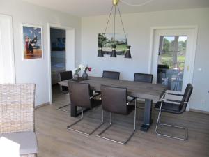 a dining room with a wooden table and chairs at Der Landhof Seeadler in Stolpe auf Usedom