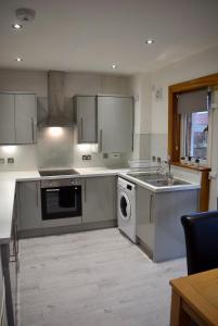 a kitchen with a sink and a dishwasher at Kelpies Serviced Apartments- Russell in Falkirk