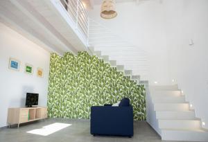 a stairway with a blue chair in a room with stairs at Case Playa Resort Balestrate in Balestrate