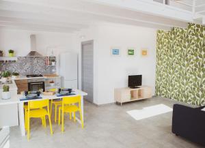 a kitchen with a table and yellow chairs in a room at Case Playa Resort Balestrate in Balestrate