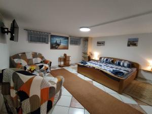 a living room with a bed and a couch and chairs at Sommertraum in Fehmarn