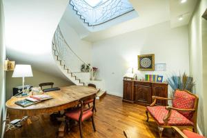a room with a table and chairs and a staircase at b&b le 4 leggende in Catania