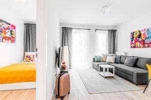 a living room with a couch and a bed at Apartamenty Homely Place Centrum - Stary Rynek - Parking in Poznań