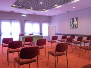 a room with chairs and a table and a whiteboard at Flag Hotel Braga in Braga