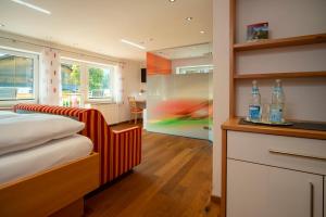 een slaapkamer met een bed en een bureau met flessen erop bij Hotel Bellevue in Riezlern