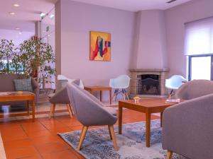 uma sala de estar com cadeiras e uma lareira em Flag Hotel Braga em Braga