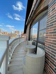 - un balcon avec des tables et des chaises dans un bâtiment dans l'établissement Гостиница Альвита Краснодар Центр, à Krasnodar