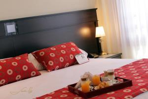 a hotel room with a tray of food on a bed at Grand Hotel Libertad in Nueve de Julio