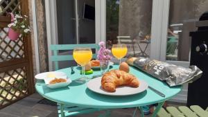 een tafel met croissants en jus d'orange en drankjes bij Le Petit Paradis - La Provençale in Lorgues