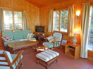 een woonkamer met een bank en stoelen en een tv bij Chalet Hildegarde by Interhome in Nendaz