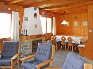 a living room with a fireplace and a table and chairs at Chalet Mungg by Interhome in Nendaz