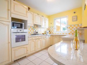 a kitchen with white appliances and a table with a bottle of wine at Villa Orée des Salines by Interhome in Le Grau-du-Roi