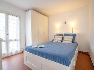 een slaapkamer met een groot bed en een blauw dekbed bij Holiday Home Grau Village by Interhome in Le Grau-du-Roi