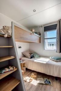 a bedroom with two bunk beds and a window at Camping Le Parc de Paris in Villevaudé +31 photos