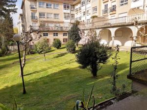 un patio verde con un edificio al fondo en Piso completo en Camiño Inglés - Sigüeiro,, en Sigüeiro