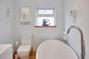 a white bathroom with a toilet and a window at Host & Stay - The Alby in Whitby