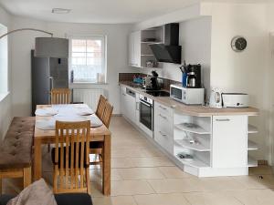 una cucina con tavolo e una sala da pranzo di Holiday Home Deichhuus Een by Interhome a Nessmersiel