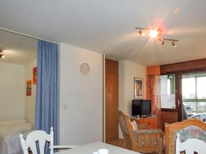 een woonkamer met een tafel en stoelen en een televisie bij Apartment F 118 by Interhome in Dittishausen