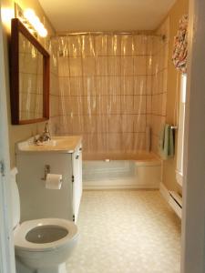 a bathroom with a tub and a toilet and a sink at Fairmont House Bed & Breakfast in Mahone Bay