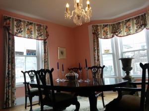 a dining room with a table and chairs and windows at Fairmont House Bed & Breakfast in Mahone Bay