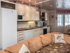 ein Wohnzimmer mit einem Sofa in der Küche in der Unterkunft Holiday Home Vuosselinhovi c by Interhome in Ruka