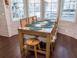 a wooden table in a room with chairs and a table at Holiday Home Vuosselinhovi c by Interhome in Ruka