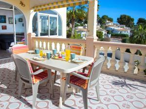 - Balcón con mesa blanca y sillas en Holiday Home Meluca by Interhome, en Calpe