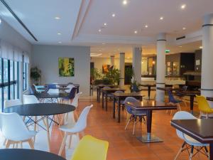 a restaurant with tables and chairs in a cafeteria at Flag Hotel Braga in Braga