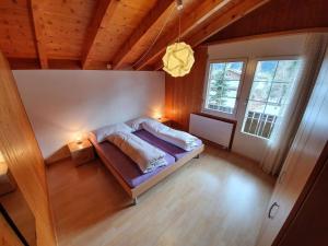 a bedroom with a bed in a room with wooden ceilings at Apartment Casa Milu by Interhome in Engelberg