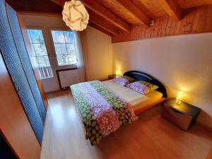 een slaapkamer met een bed en een groot raam bij Apartment Casa Milu by Interhome in Engelberg