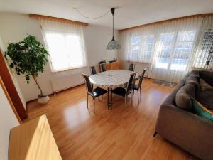 een woonkamer met een tafel en stoelen en een bank bij Apartment Casa Milu by Interhome in Engelberg