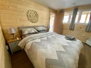 a bedroom with a bed in a wooden wall at Southernwood - Wantage Road Lodge in Didcot