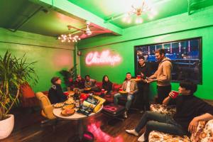un grupo de personas sentadas en una habitación en HOSTEL CHILLAX, en Osaka