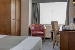 a hotel room with a bed and a desk and a chair at Lion Hotel in Worksop