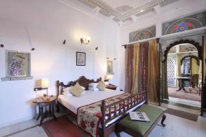 a bedroom with a bed and a room with a table at Amet Haveli in Udaipur