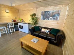 uma sala de estar com um sofá de couro e uma mesa em Southernwood - Wantage Road Lodge em Didcot