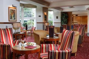 a restaurant with chairs and tables in a room at Best Western Homestead Court Hotel in Welwyn Garden City
