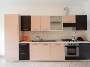 een keuken met houten kasten en een fornuis bij Apartment Riva Mare by Interhome in Riva Ligure