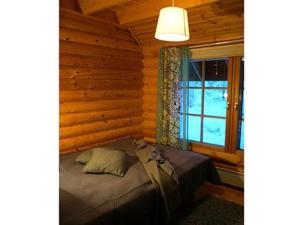 sypialnia z łóżkiem w drewnianym domku w obiekcie Holiday Home Metsä-pihlaja by Interhome w mieście Kinnula