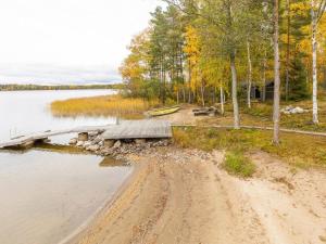 a dirt road next to a lake with a dock at Holiday Home Ranta 3 by Interhome in Vääksy