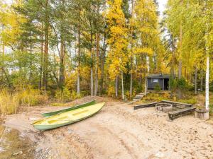 a yellow canoe sitting on a dirt road in a forest at Holiday Home Ranta 3 by Interhome in Vääksy