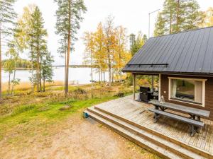 a cabin with a bench on a wooden deck at Holiday Home Ranta 3 by Interhome in Vääksy