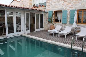 a patio with chairs and a swimming pool at Eski Tas Hotel in Çeşme
