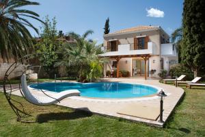 a swimming pool in front of a house at Pandora Villas in Hersonissos