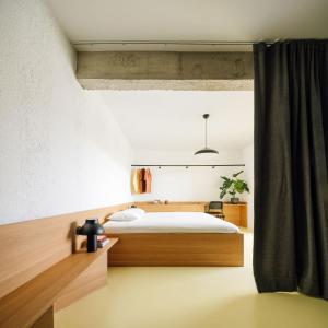a bedroom with a bed with a wooden headboard at Equador Studios by Olala Homes in Cascais