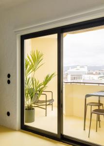 una porta scorrevole in vetro con una pianta sul balcone di Boavista Apartment by Olala Homes a Cascais